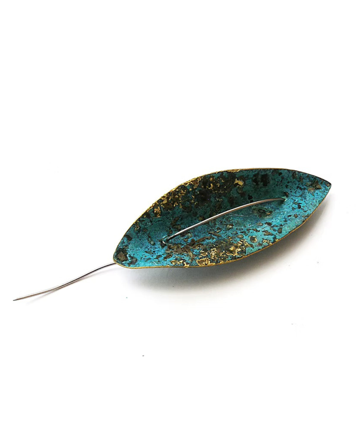 A leaf-shaped brooch with a distressed turquoise and gold patina finish and a silver-tone pin wire backing, shown on a plain white background. Handmade Float Pin by Karin Beaumont.